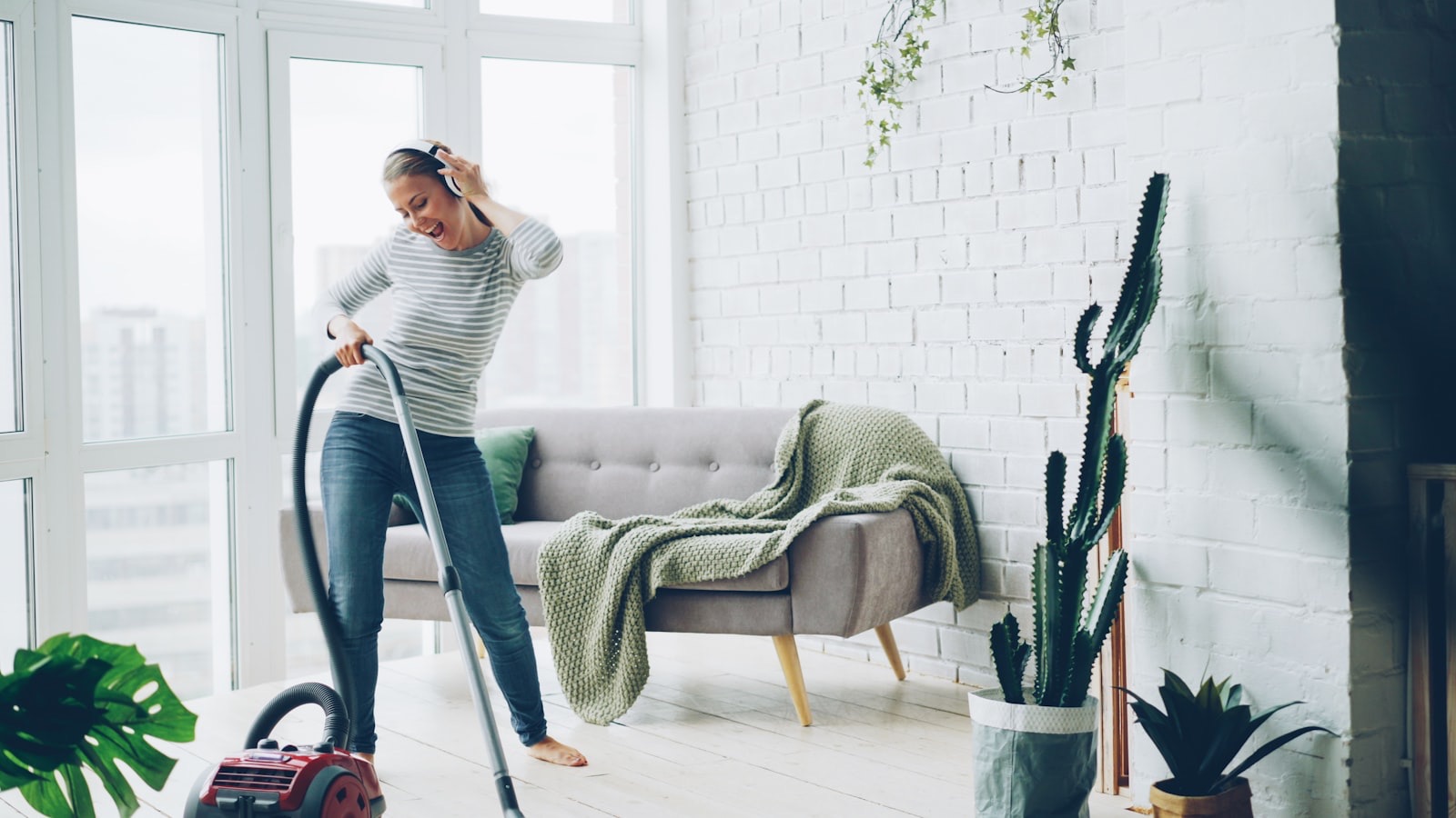 House cleaner vacuuming the floor of a bright living room